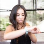 woman looking at apple watch before an arm workout